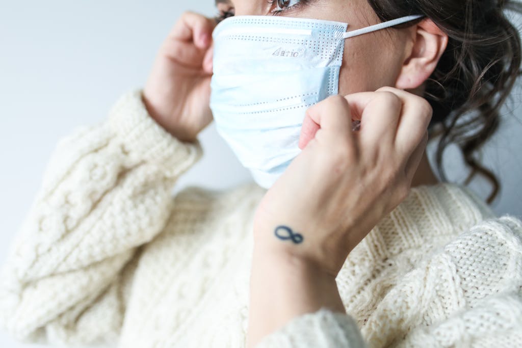 A woman adjusting a protective face mask, emphasizing health and safety measures.